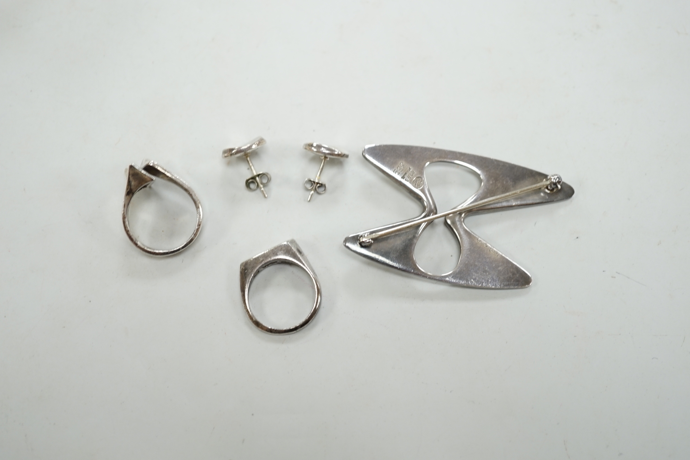 A Georg Jensen sterling free form brooch, design no. 369, a pair of Georg Jensen ear studs and two white metal rings.